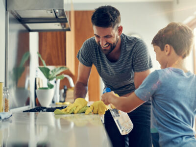 The super disinfecting son and dad duo. Shot of a father and son cleaning the kitchen counter together at home.