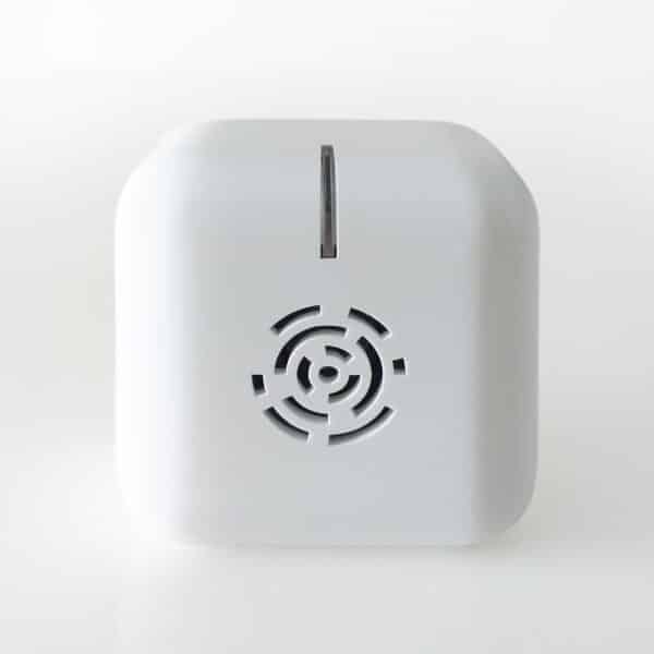 A compact white cube electronics device featuring a circular front vent and single top slot, set against a plain white background.